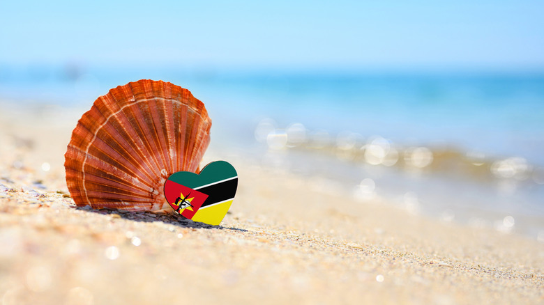 Shell and heart-shaped Mozambique flag on beach