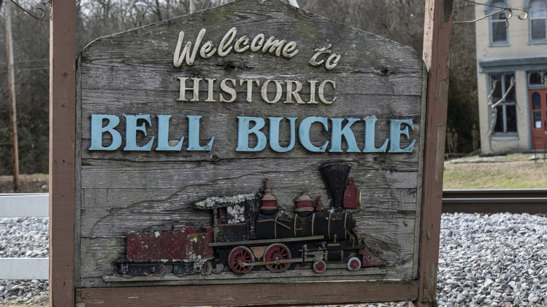 The entrance sign to Bell Buckle, made from wood and with a train under the town's name