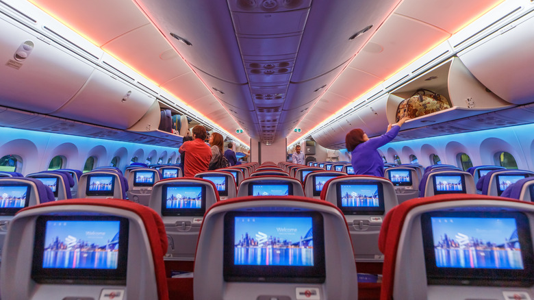 The interior cabin of a LATAM Airlines plane with screens in the seatbacks