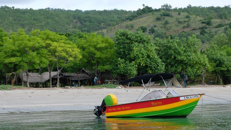 Colorful speedboat moored at the shore of one of the beaches at Ataúro Island in Timor-Leste