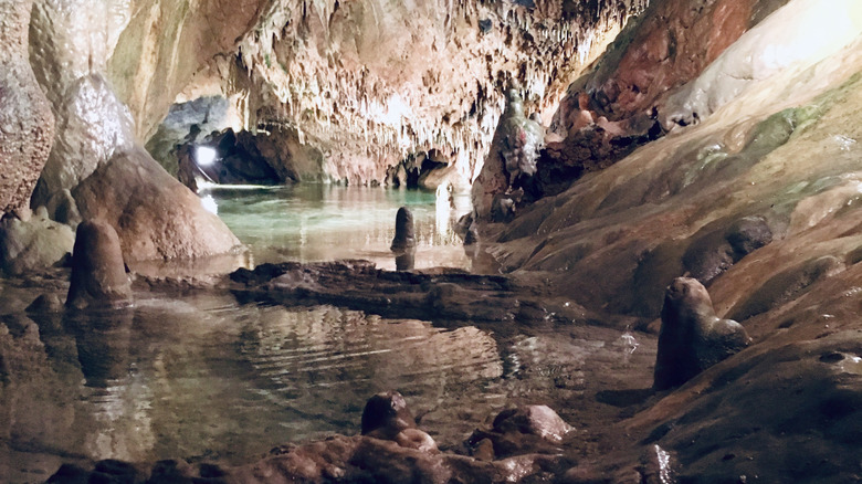 The clear water of crystal lake, illuminated and surrounded by underground rock formations.