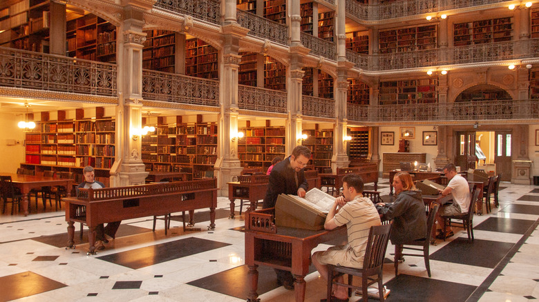 People sitting at desks in George Peabody Library atrium.