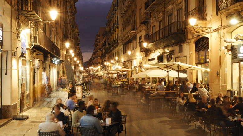 A busy street in Palermo, lined with restaurants at night