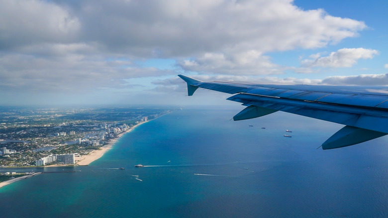 Aerial view of Fort Lauderdale-Hollywood International Airport and ocean with the wing of a plane