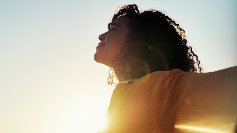 A woman embracing fresh air and sunlight