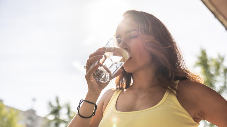 Woman drinking a glass of water outside