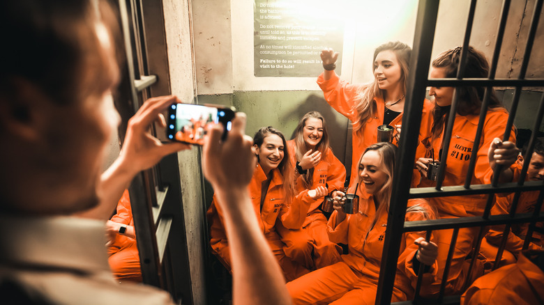 Girls in jumpsuits pose for a photo at Alcotraz Bar