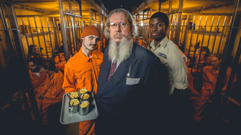 Actors playing warden, guard, and prisoner holding a tray of drinks pose at the Alcotraz Bar