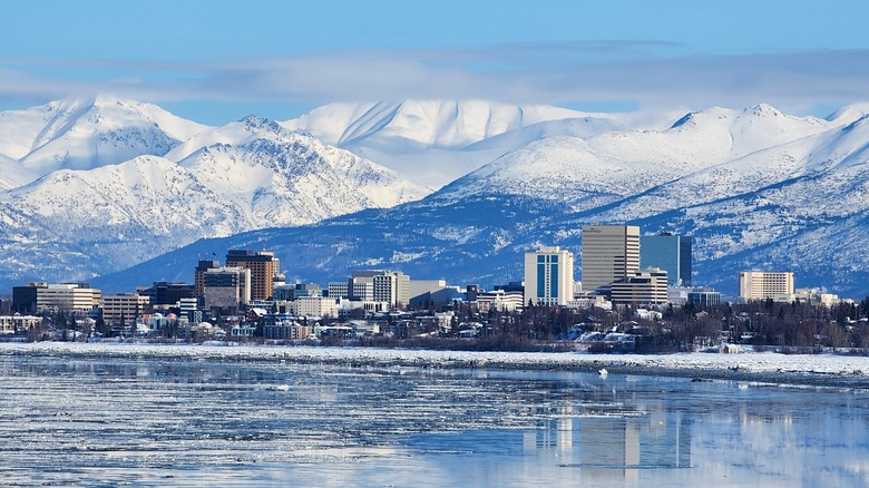 Snowy mountains, buildings and water in Anchorage, Alaska during the day