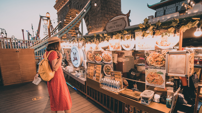 woman checking out Thai food offers at Global Village in Dubai