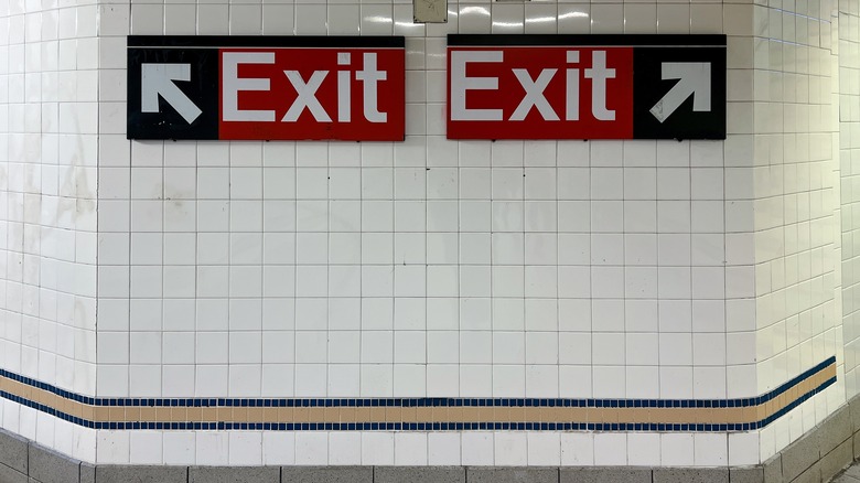 Two exit signs in subway station