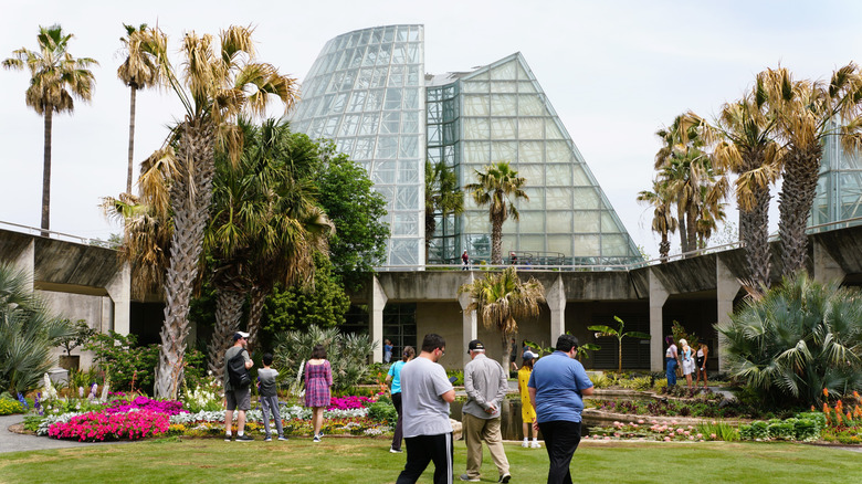 Visitors walking outside of a futuristic glass structure at the San Antonio Botanical Gardens