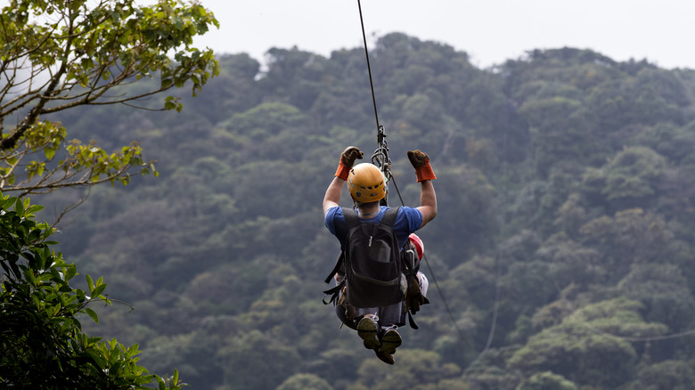 Man riding a zip line through Costa Rica's jungle