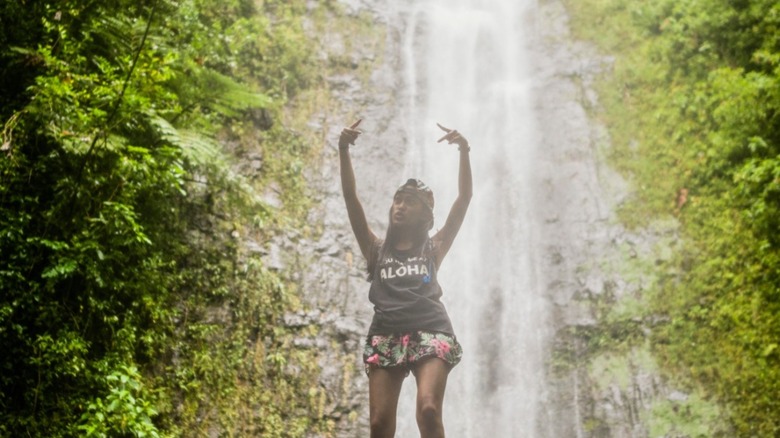 A woman poses in front of Manoa Falls