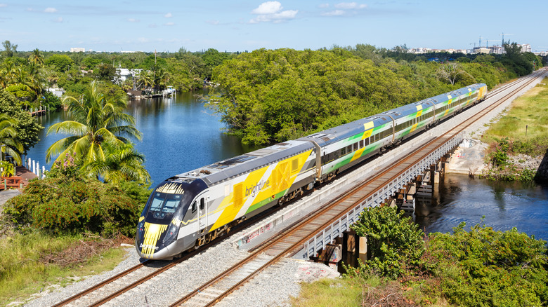 Brightline train crosses a bridge over a river in Florida