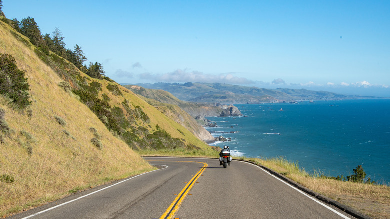 Motorcycle driving down PCH in California with views of the ocean