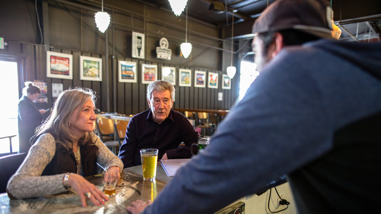 Bartender talking to a couple inside a Denver brewery