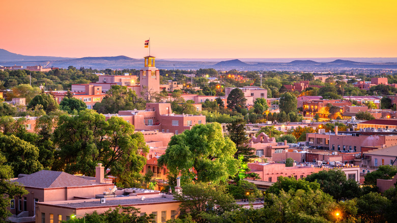 The Santa Fe skyline at dusk, with tan buildings and an orange/yellow sky