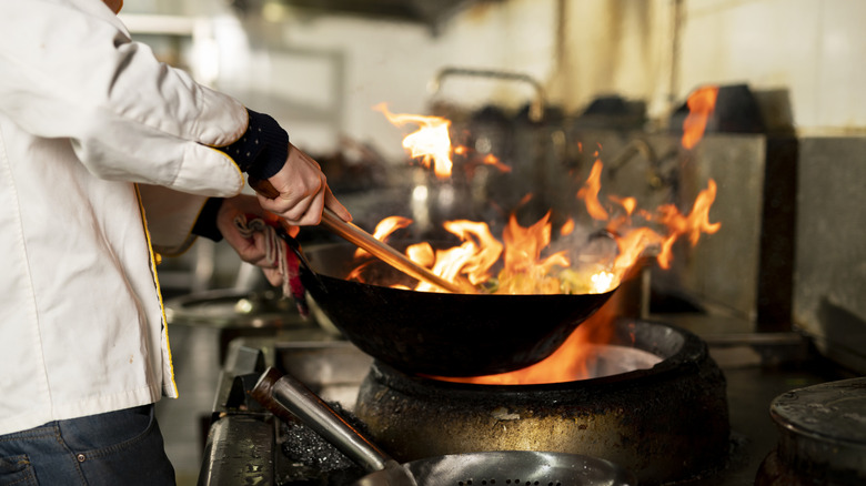 A chef cooking with a wok