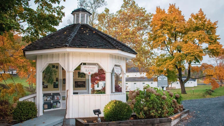 A white gazebo with a welcome sign to Warm Springs Pools