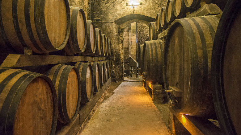 large wine barrels lined up in vaulted cellar