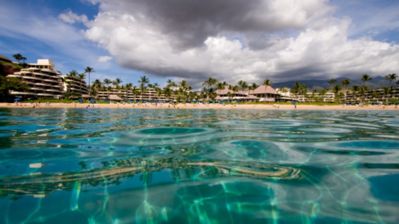 Clear blue sea water of Kaanapali Beach with hotels in the distance