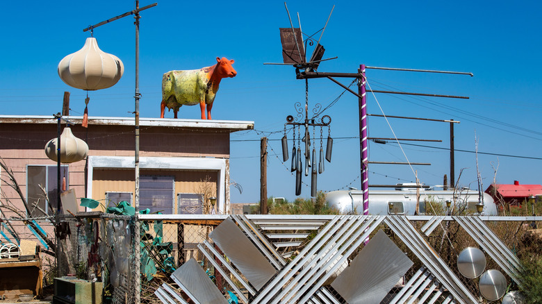 Art pieces including a cow on a roof in Bombay Beach, California