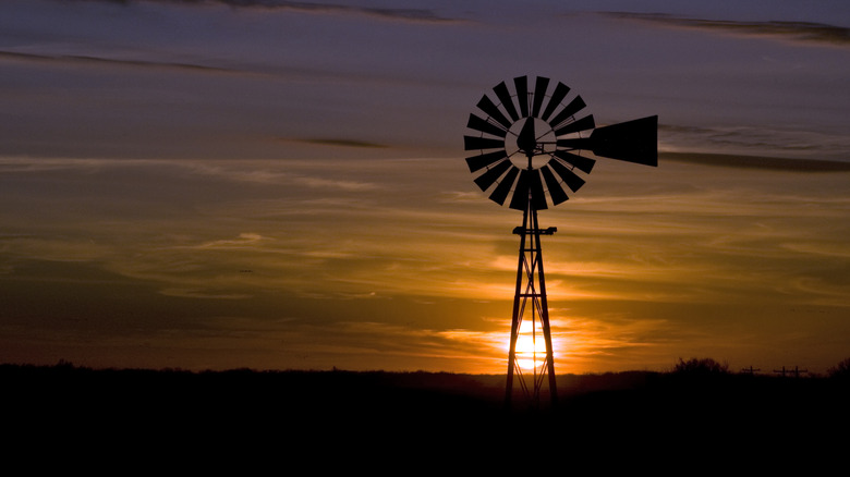 Windmill in silhouette at sunset on the plains