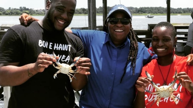 Tia beams with two tour guests and their crab haul