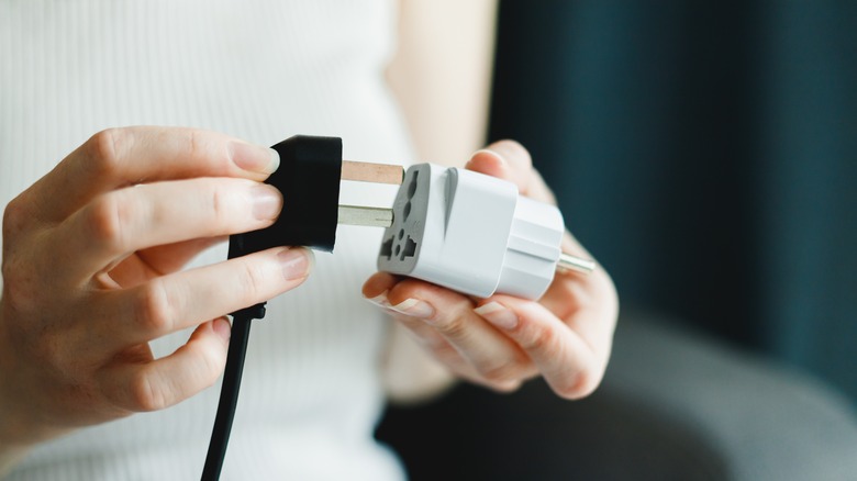 Woman testing a travel adapter