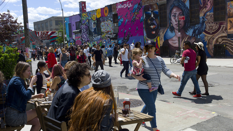 People walking along mural streets in Bushwick, New York