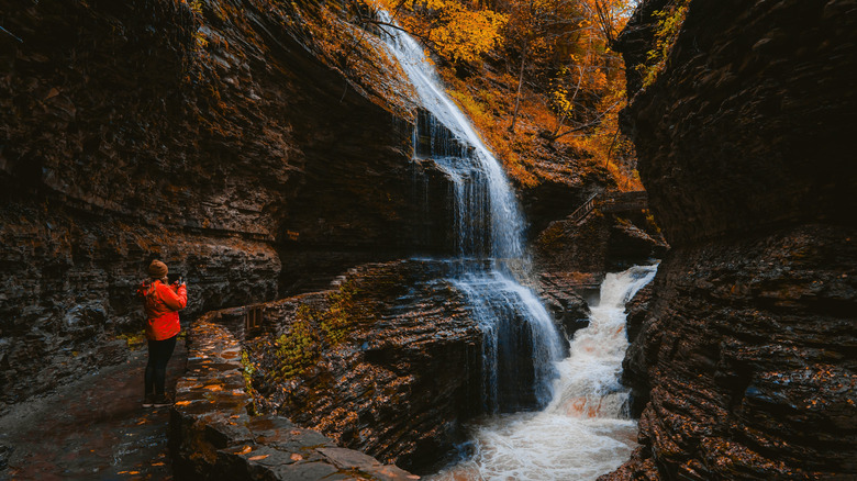 A hiker takes a picture at Watkins Glen in New York in the fall