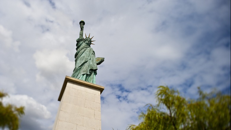 Statue of Liberty replica beneath the clouds