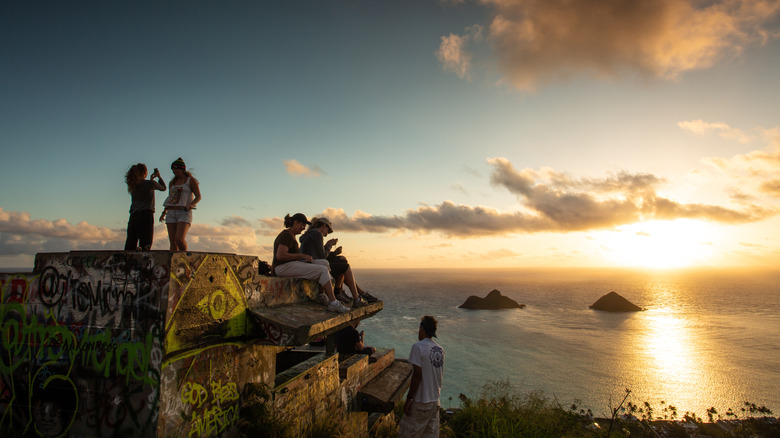 A group of hikers sitting on the pillbox at the end of Lanikai Pillbox hike