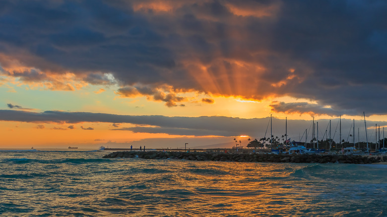 Sunset over water with boats in distance