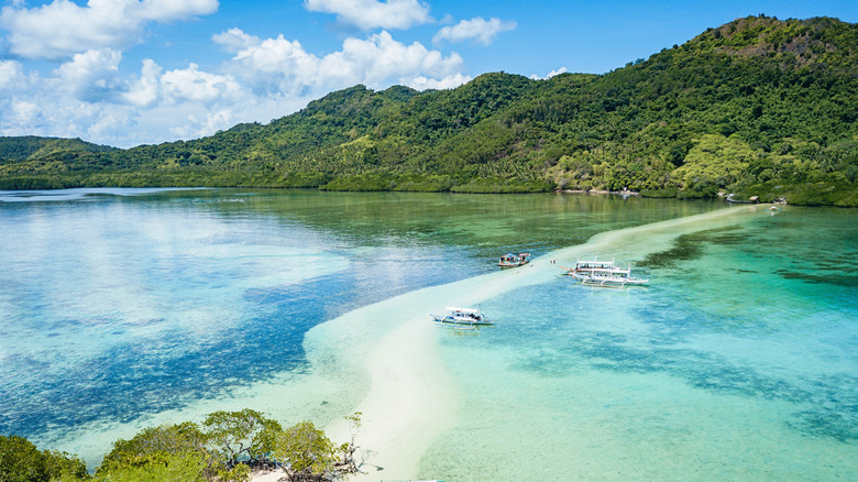 Sand bar with boats at Snake Island in El Nido in the Philippines