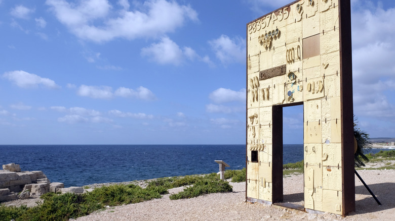 The Gate of Europe sculpture standing at the edge of a shore in Lampedusa, Italy