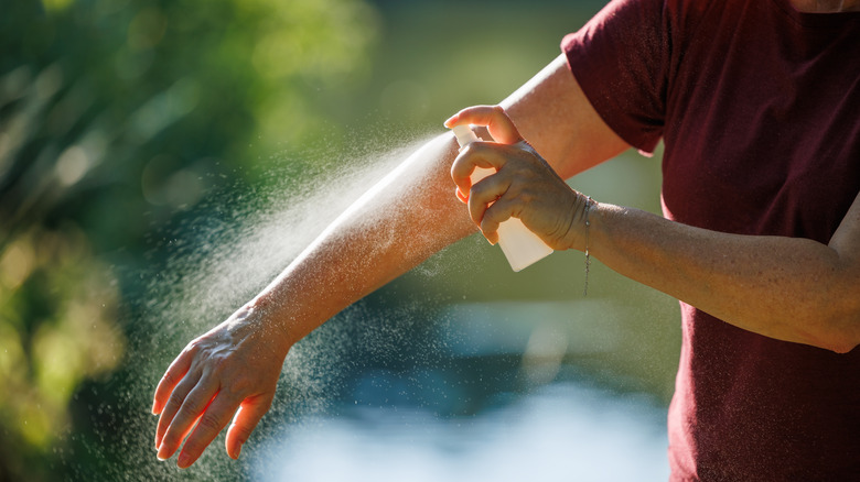 Woman applying insect repellent on her arm