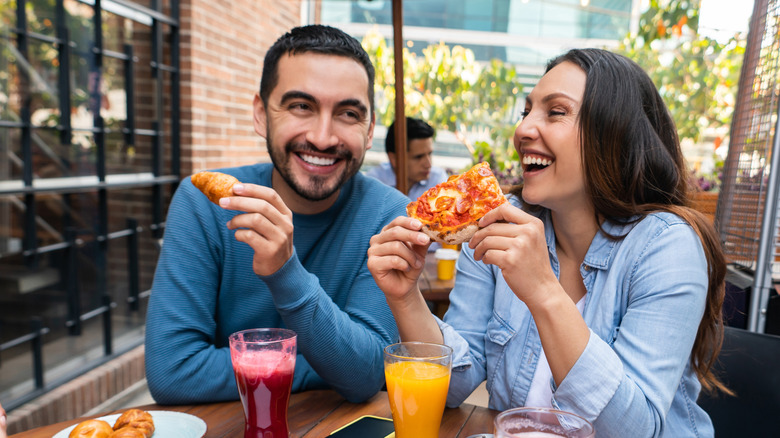 A couple enjoying pizza at a restaurant