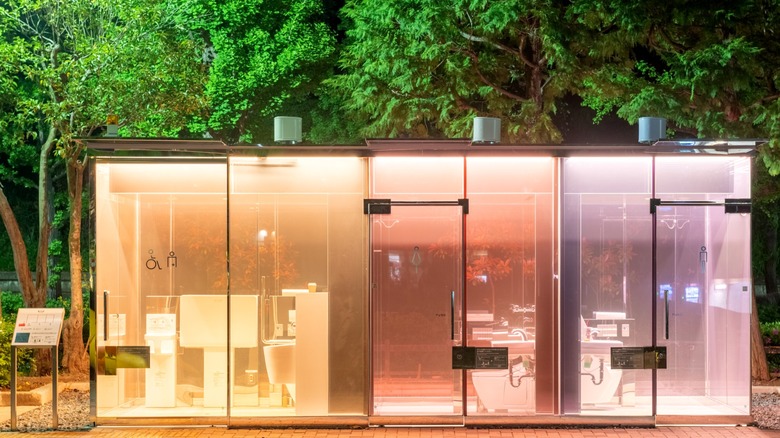 Transparent, colorful public toilets, designed by Shigeru Ban for the Tokyo Toilet project, seen here at night in Yoyogi Fukamachi Mini Park in Shibuya district in Tokyo, Japan