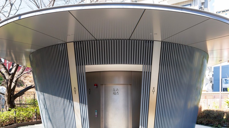 Image of a circular public toilet called "Amayadori", located in Jingu-Dori Park and designed by Tadao Ando for the Tokyo Toilet project in Shibuya district, Tokyo, Japan