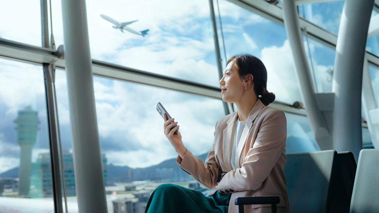 Traveler at an airport with their phone out