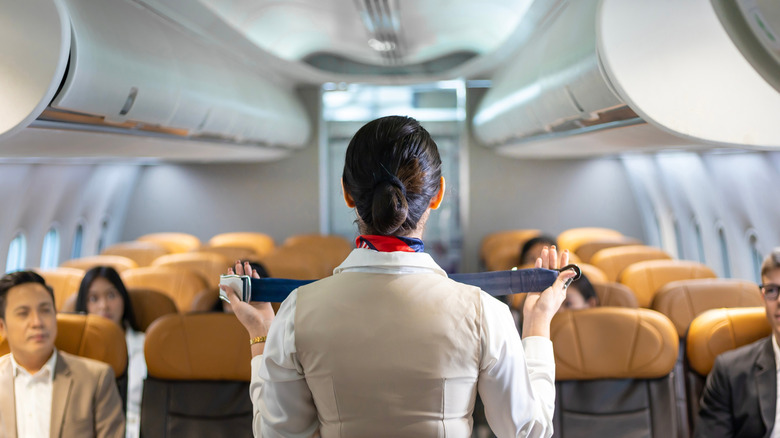 Flight attendant doing safety briefing on plane