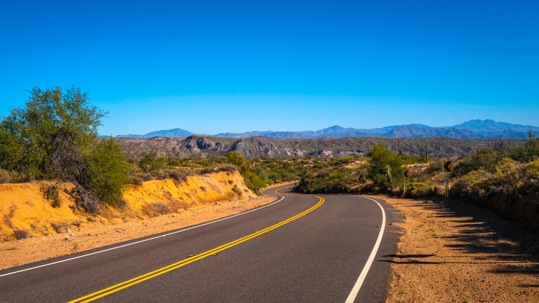 A two-lane road cutting through the Arizona desert