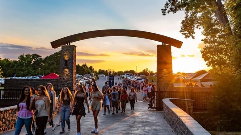 Group of fans walking into FirstBank Amphitheater at sunset