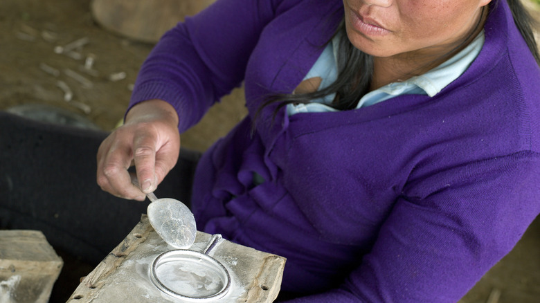 Metalworker in Ban Napia makes a bracelet out of Vietnam war debris