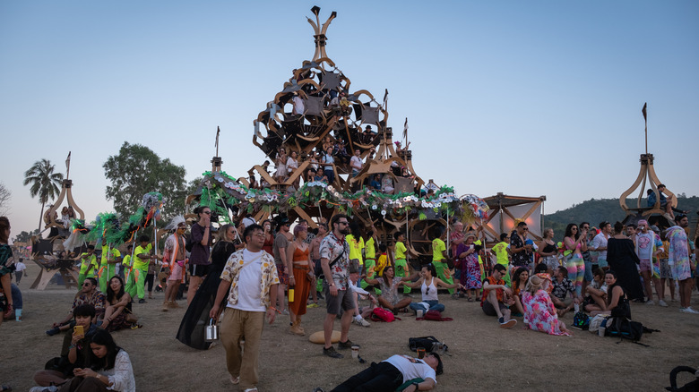 People at the Wonderfruit Festival in Thailand by a large structure