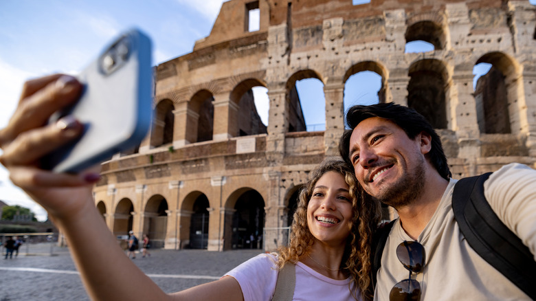 Couple with camera by Rome's Colosseum