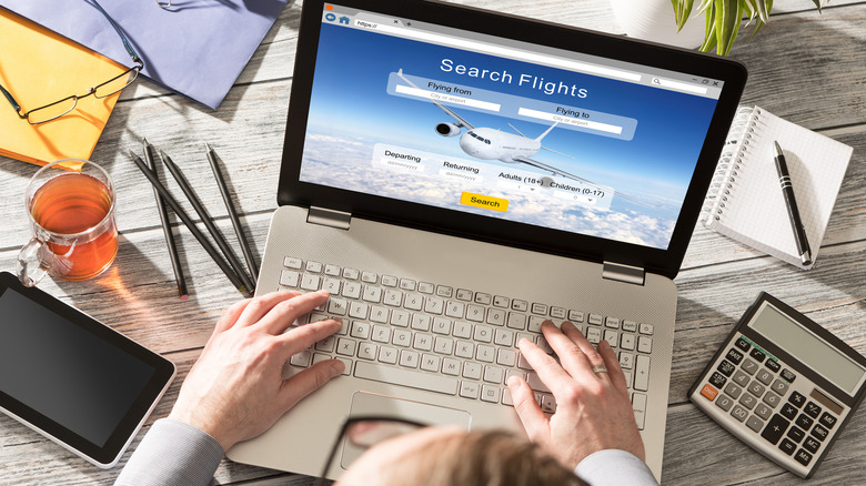 Person booking a flight on computer 