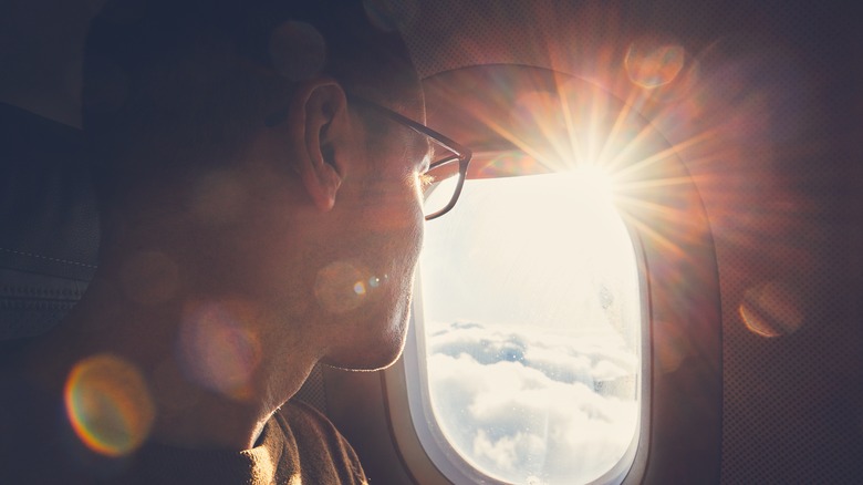 man watching sunrise airplane window